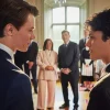 Main characters of Young Royals, Simon and Wilhelm, look at each other in front of the royal Swedish family.