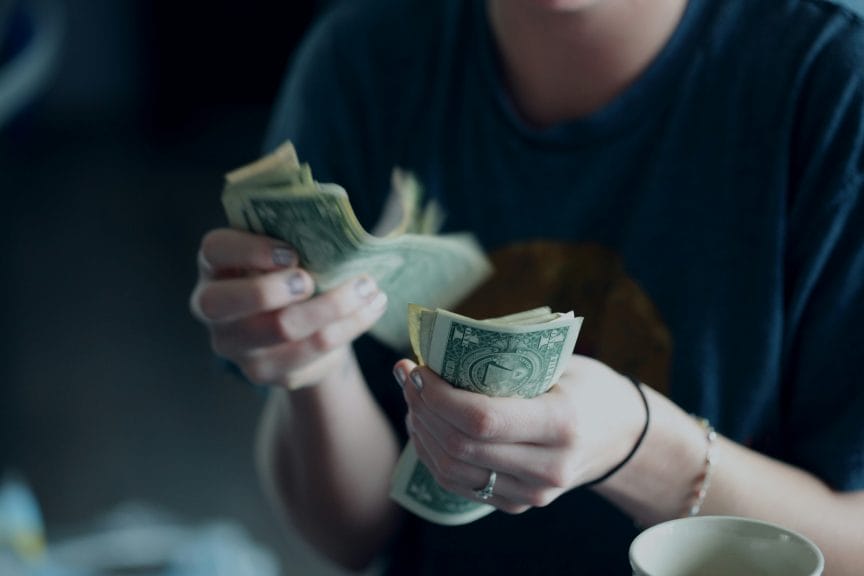 person counting money in their hands, no face is shown