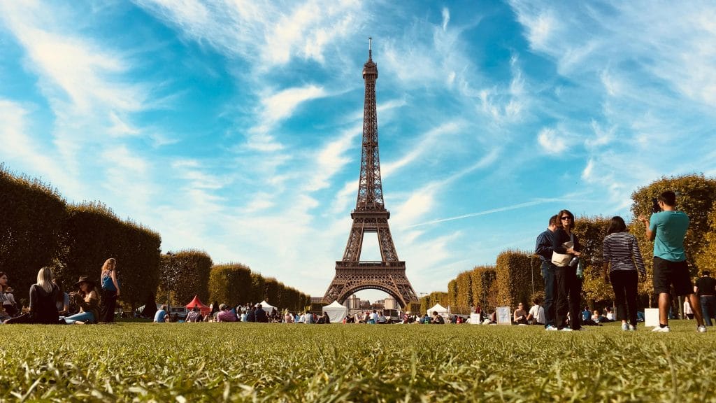Scene in front of Eiffel Tower during sunny day.