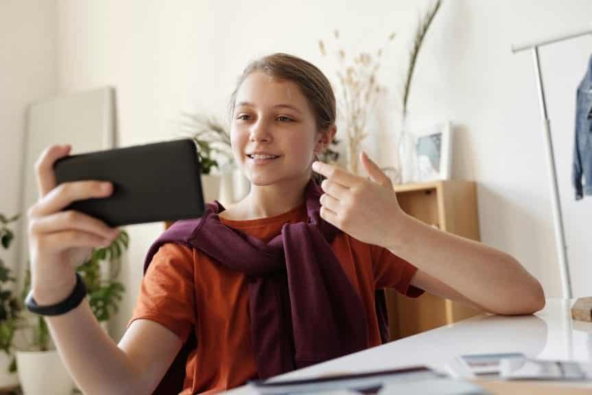 kid influencer making a get ready with me video on an iphone to post on social media