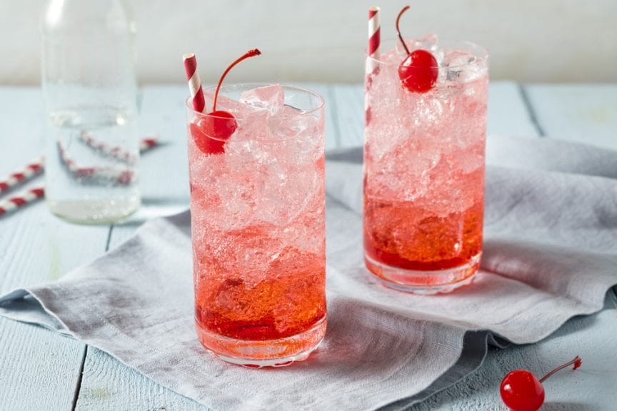 Two Shirley Temple beverages sitting on a table.