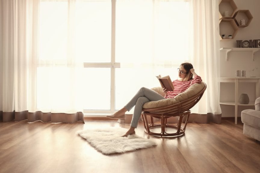 woman reading in a chair  in a bright room and not doing screen time