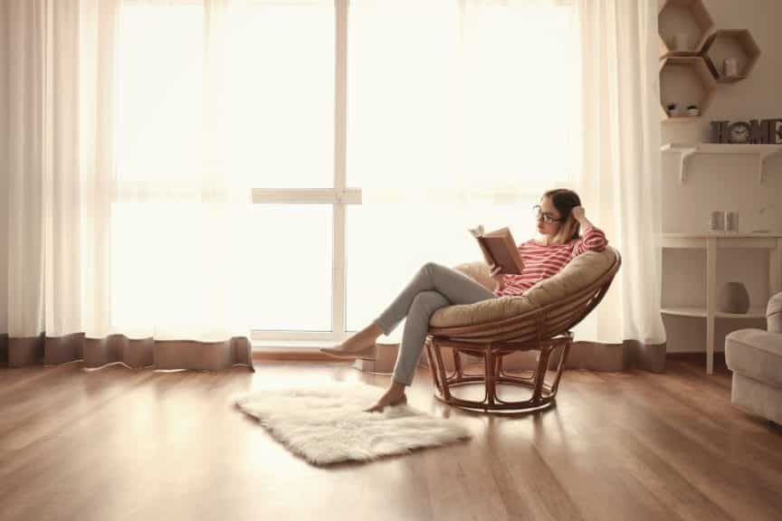 woman reading in a chair in a bright room and not doing screen time