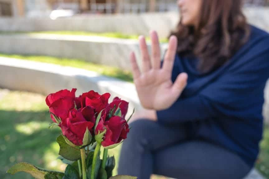 Woman rejecting a bouquet of roses, directly rejecting the catch after the chase