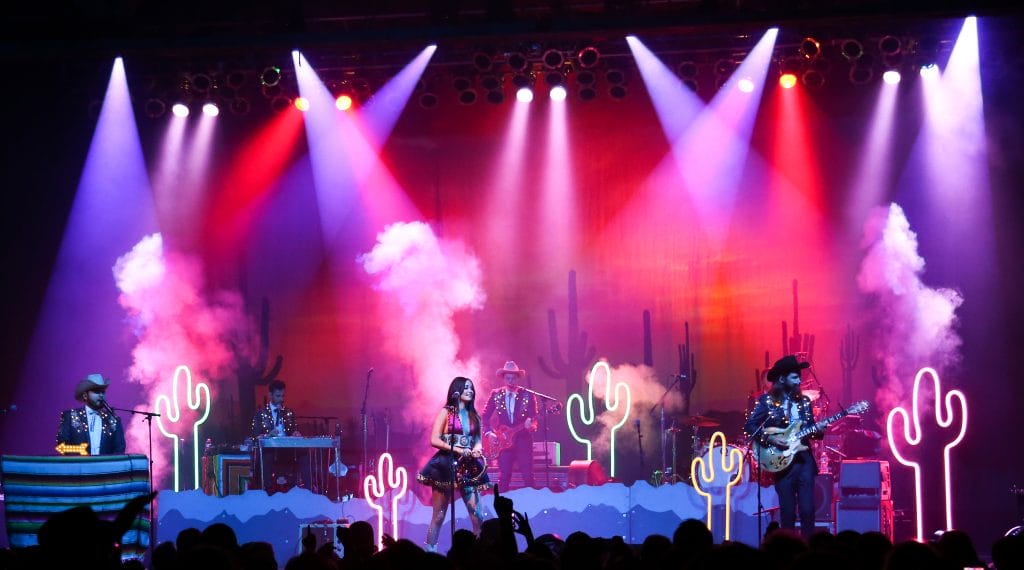 An expansive view captures Kacey Musgraves' performance on the grand stage of the Paramount in Huntington, NY on July 18, 2015. Amidst a backdrop of dazzling stage lights, the country musician's presence fills the venue as she engages the audience with her music and charisma.