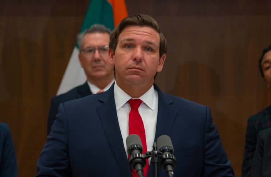 Image shows Ron DeSantis at a press conference.