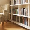 A armchair and ottoman sitting in front of a bookshelf.