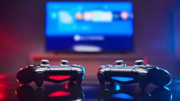 Two Video Game controllers, videogame joystick or gamepad on a table one red and one blue. Close up studio shot