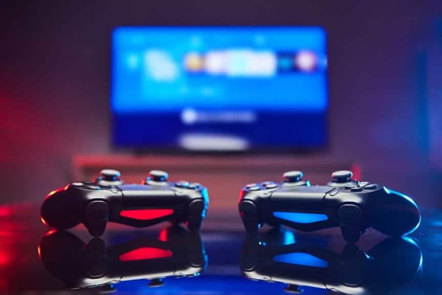 Two Video Game controllers, videogame joystick or gamepad on a table one red and one blue. Close up studio shot