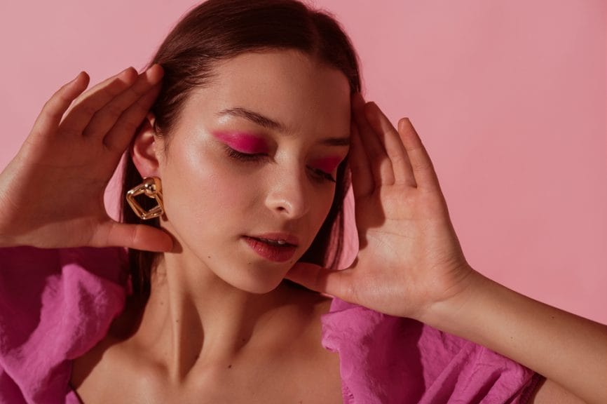 Woman with hot pink eyeshadow with a pink background