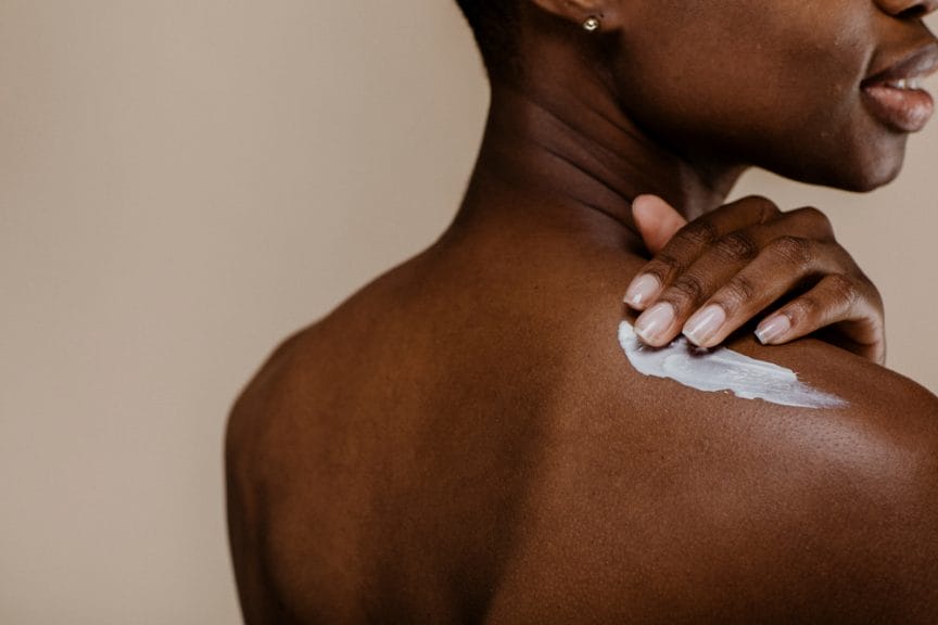 Woman applying body lotion.