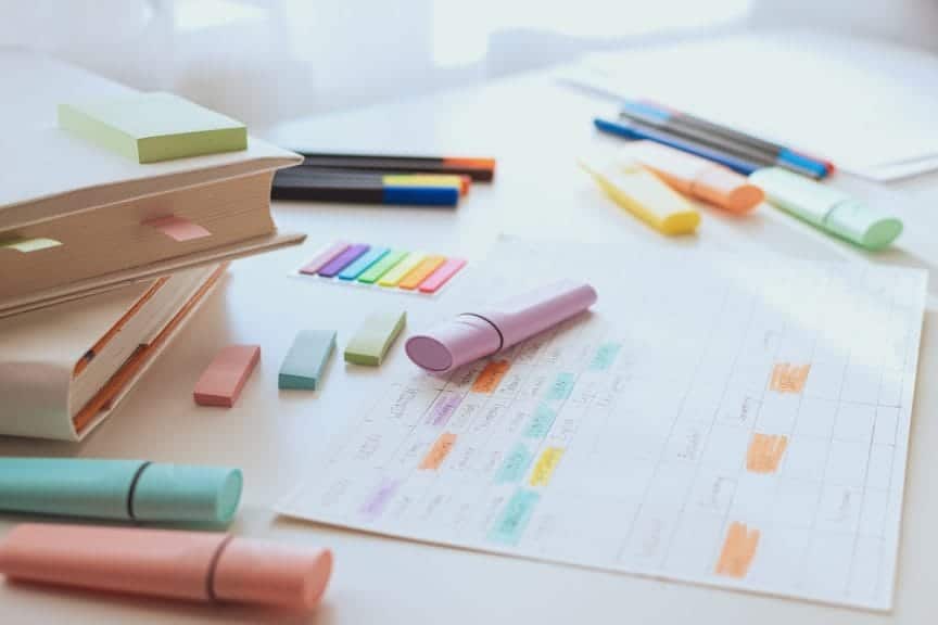 various study materials such as paper, sticky notes, and highlighters.