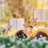 two people lying in grass and reading