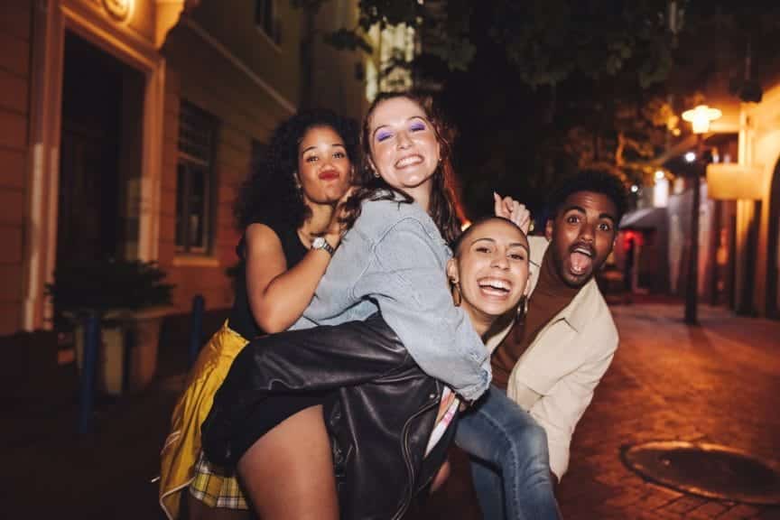 Four friends smiling while spending a weekend traveling a city
