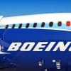 Close-up shot of Boeing plane with open exit door passenger windows.
