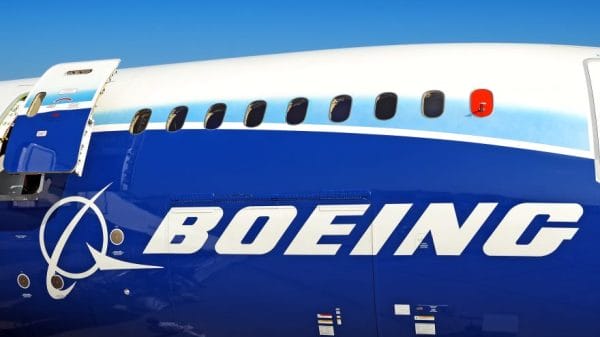 Close-up shot of Boeing plane with open exit door passenger windows.