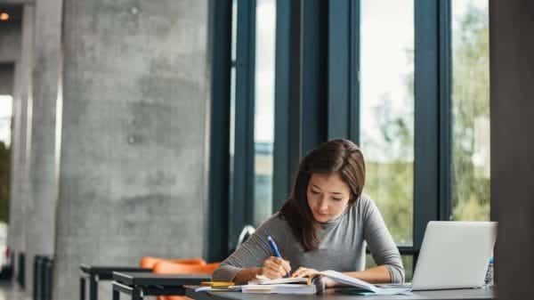 Young female student studying in library.