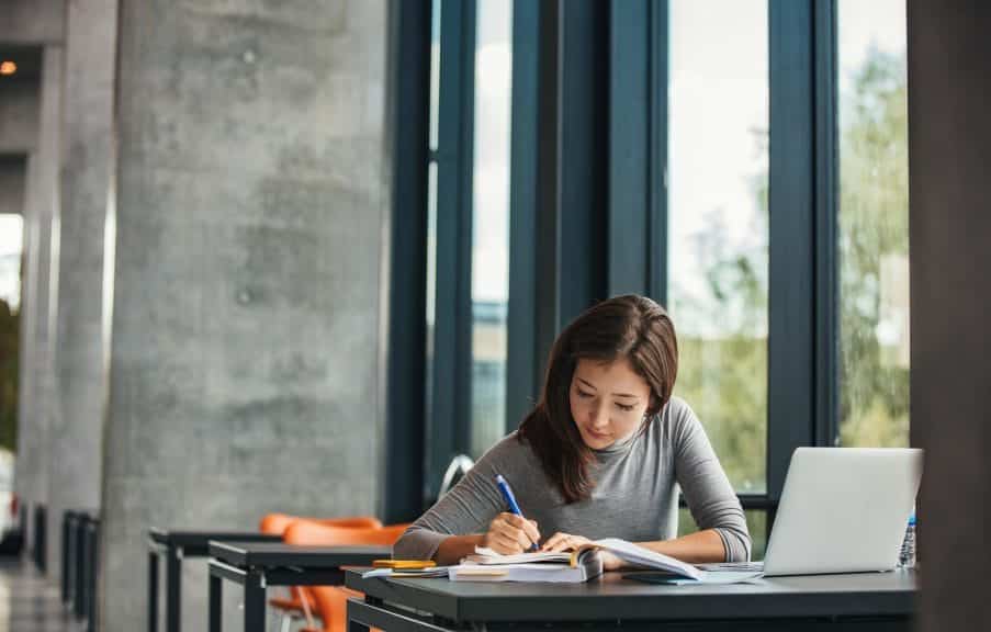 Young female student studying in library.