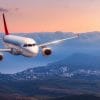 airplane flying during sunset with mountains in the background