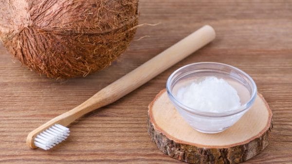 coconut and oil on table with toothbrush