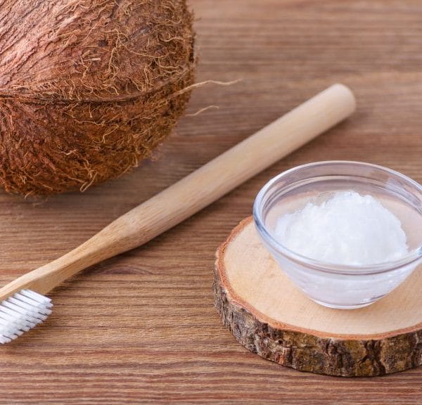 coconut and oil on table with toothbrush