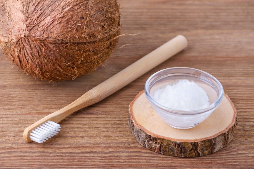 coconut and oil on table with toothbrush