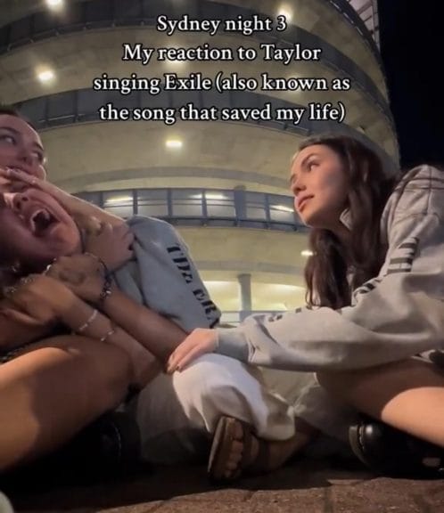 A still TikTok screenshot of a girl screaming, being comforted by friends with the caption "my reaction to Taylor singing Exile (also known as the song that saved my life)