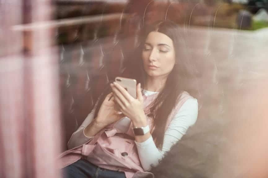 Woman sitting on the train looking at her phone.