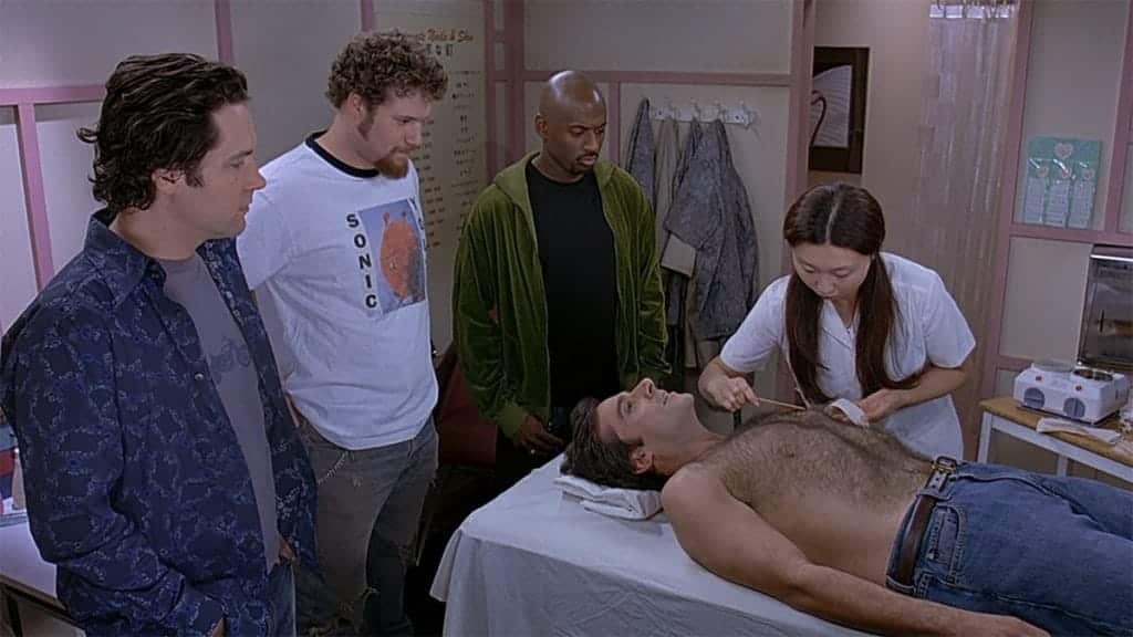 David (Paul Rudd), Cal (Seth Rogen), and Jay (Romany Malco) are watching Andy (Steve Carrell) get his chest waxed for the first time.