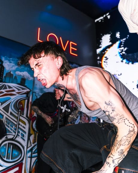 Punk performer with a cross necklace dangling from their neck