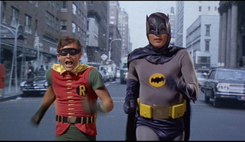 Batman (Adam West) and Robin (Burt Ward) run down the street in Gotham City.
