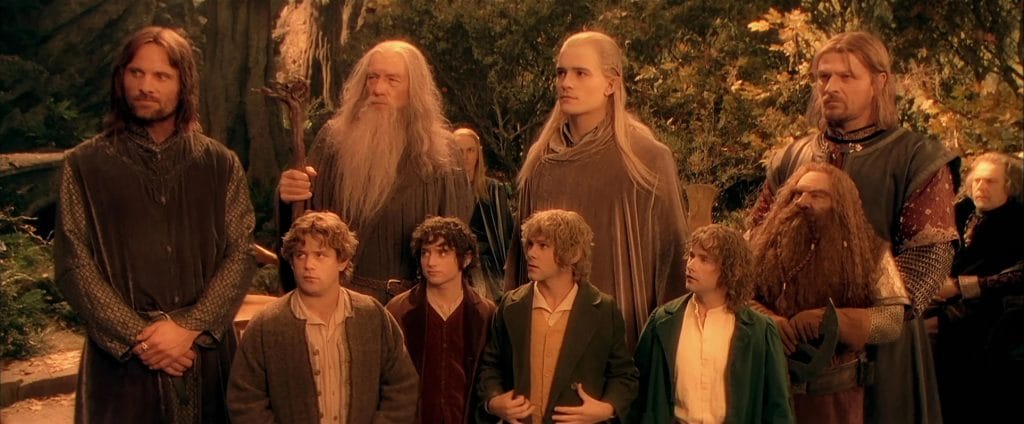 The Fellowship of the Ring (Vigo Mortensen, Sean Astin, Ian McKellen, Elijah Wood, Dominic Monaghan, Orlando Bloom, Billy Boyd, John Reyes-Davies, and Sean Bean from left to right) standing together in Rivendell.