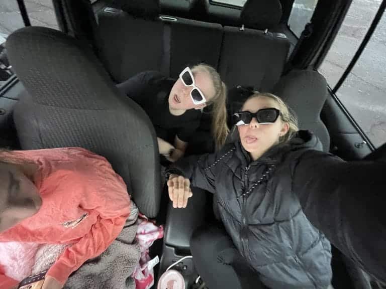 Three girls wearing sunglasses and listening to music.