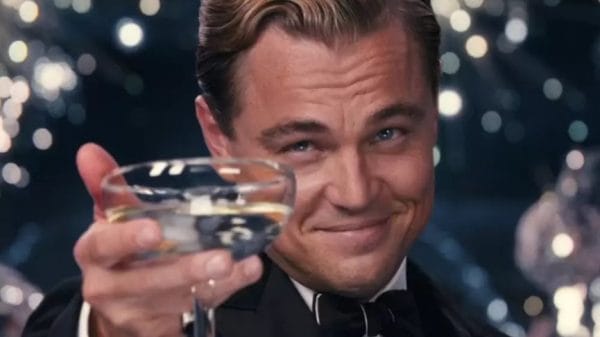 Jay Gatsby (Leonardo DiCaprio) looks into the camera with a glass.