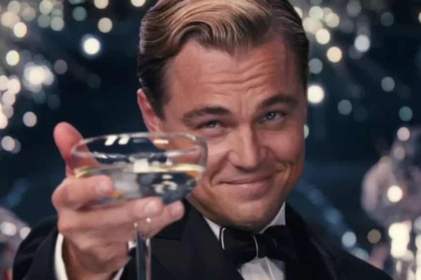 Jay Gatsby (Leonardo DiCaprio) looks into the camera with a glass.