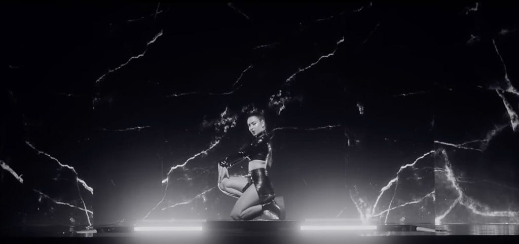 Charli XCX against a black marbled backdrop