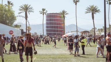 Sunny at Coachella music festival with people walking.