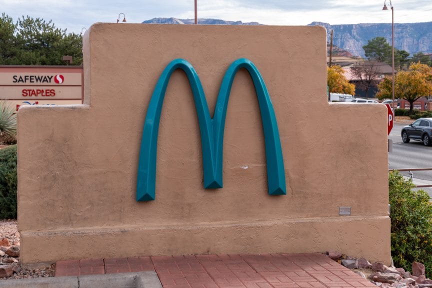 A pale red wall with a large blue M on it