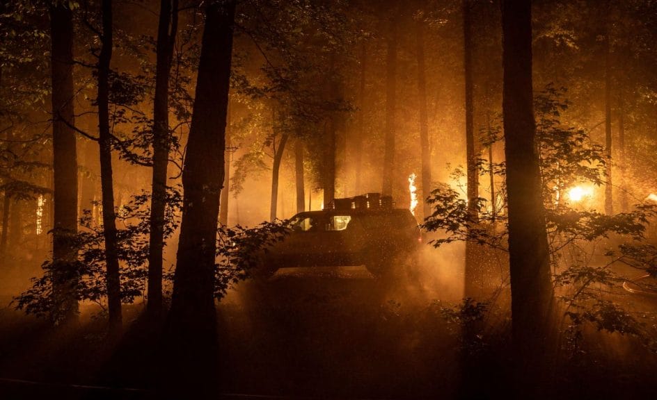 A press truck drives through a burning forest in Civil War. 