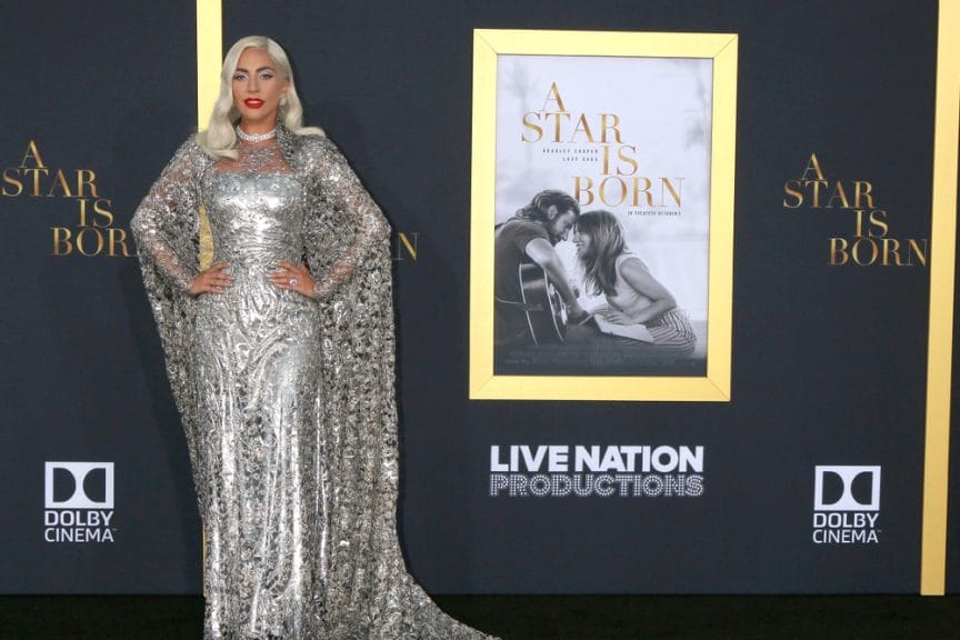 Lady Gaga on the carpet for the film "A Star is Born," dressed in a silver gown.