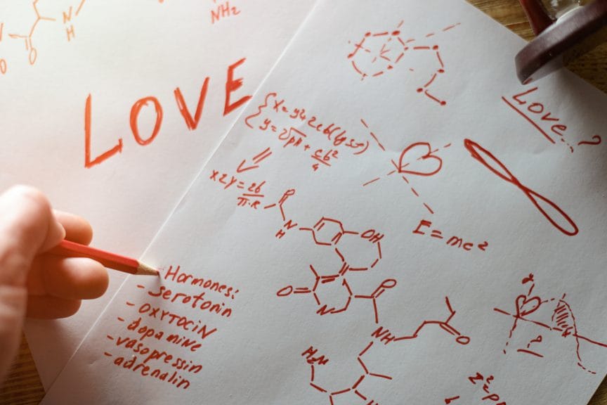 The concept of love as hormones. Sheets of paper written with formulas in search of an answer to the question of what is love .