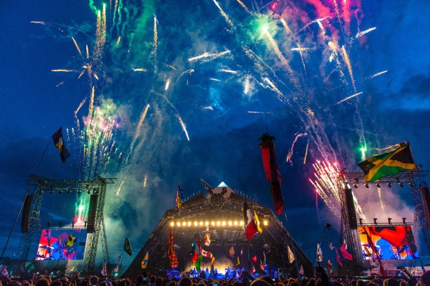 Pyramid stage at Glastonbury Festival with fireworks and flags