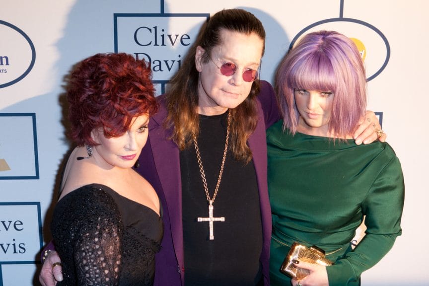Kelly Osbourne pictured with dad Ozzy Osbourne and mum Sharon Osbourne on a red carpet.