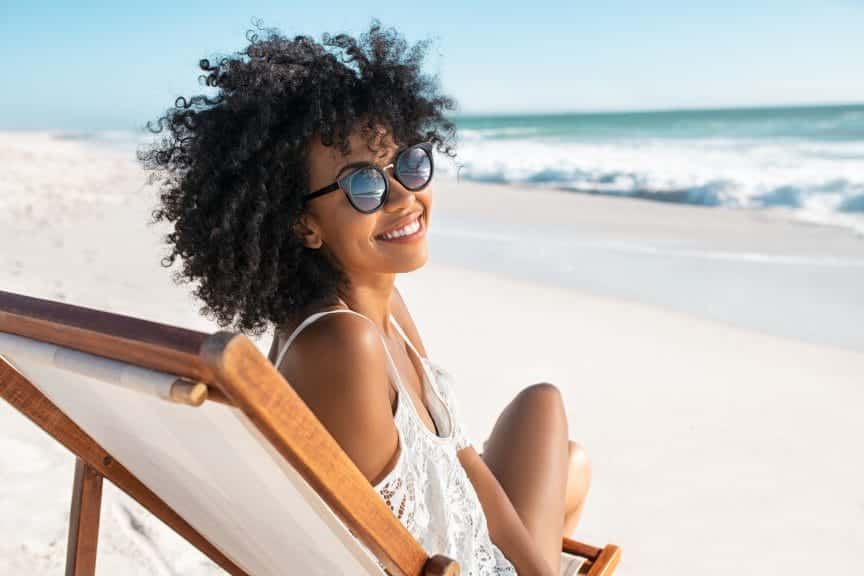 Women smiling on the beach for summer break.