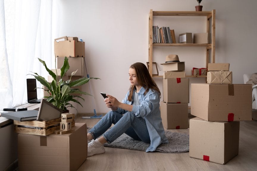 Girl home surrounded by boxes