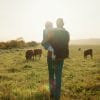 A father and child overlooking cattle on a farm