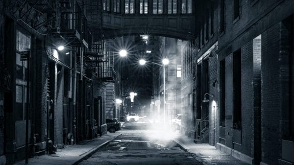 A black and white photo of an almost empty street in New York City.