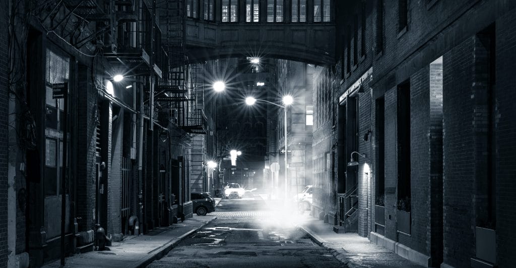 A black and white photo of an almost empty street in New York City.