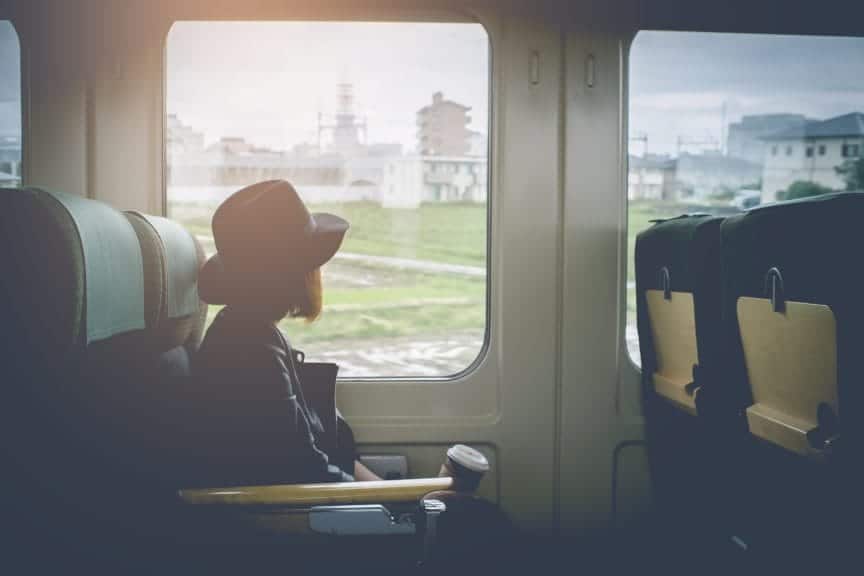 Female sat in train. Looking out window. 