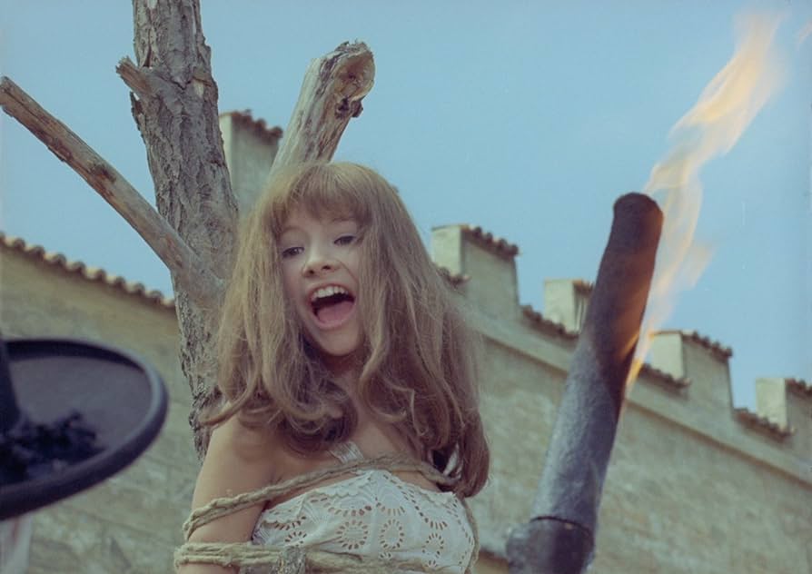 Valerie smiles as she is burned at the stake in the most iconic scene of this dreamy must-watch fantasy.